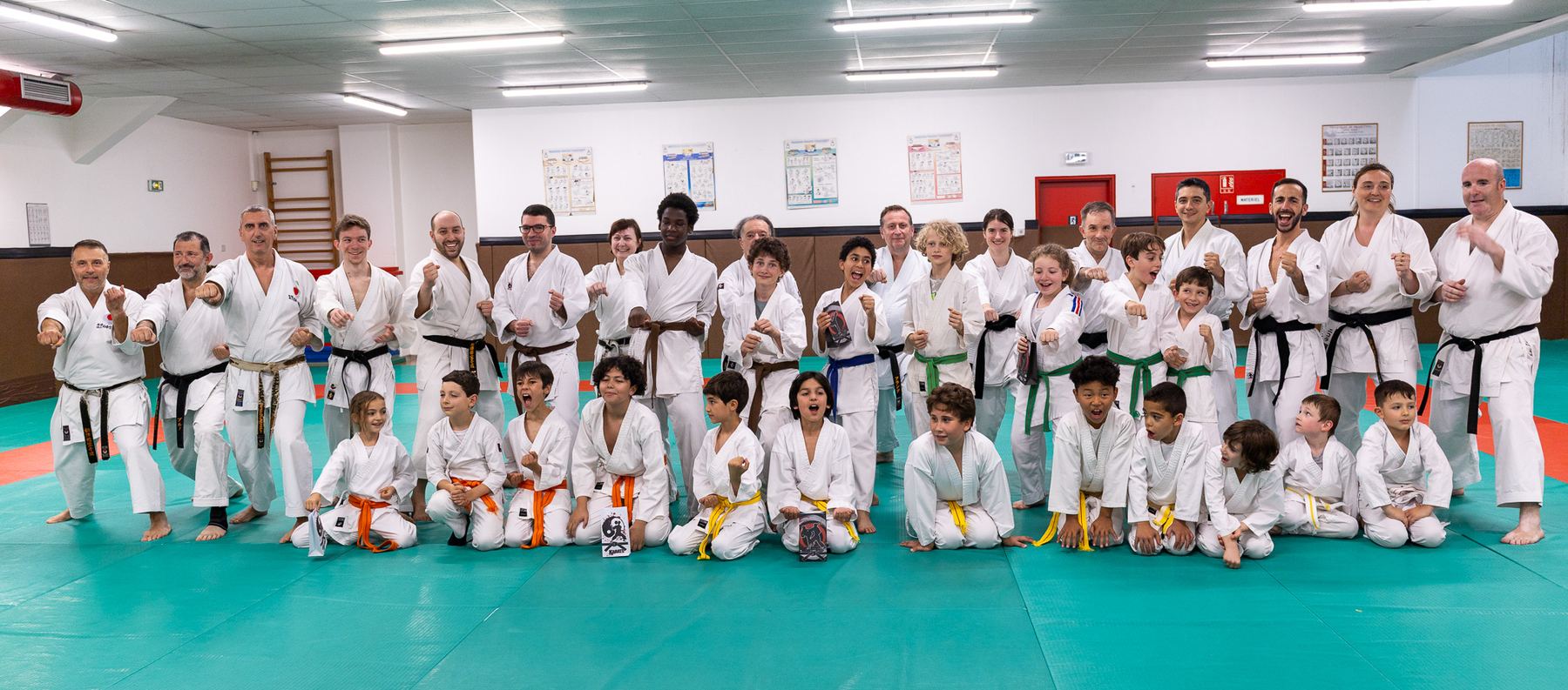 Les adhérents du club, enfants et adultes, réunis sur le tatami lors de la fête de fin d'année